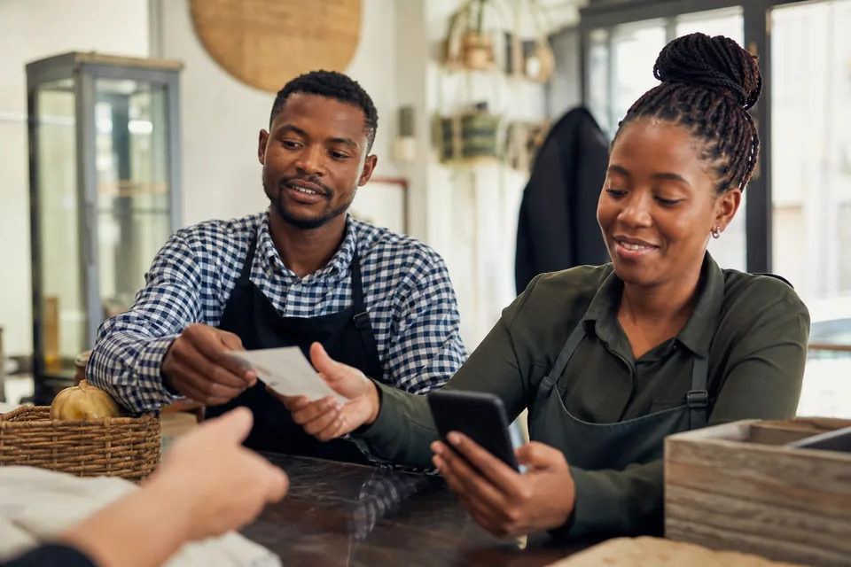 Shop staff coordinating customer replies together at the counter